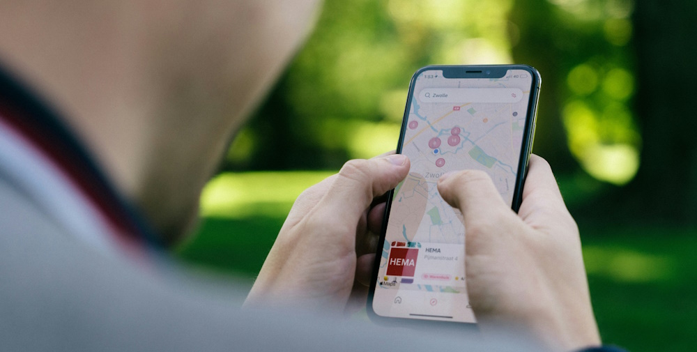 person using a map app on a mobile phone in a park