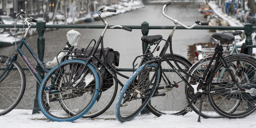 Bicycles Parked on a Canal Bridge in Amsterdam by Ernest Ojeh