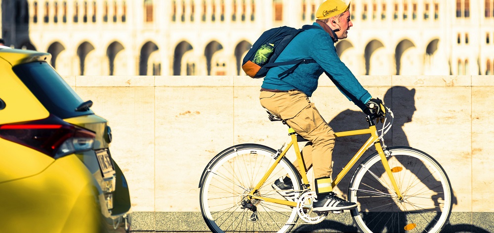Man cycling on a sidewalk in Budapest by Yury Kirillov
