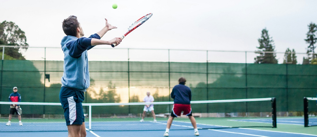 Friends playing a doubles tennis match