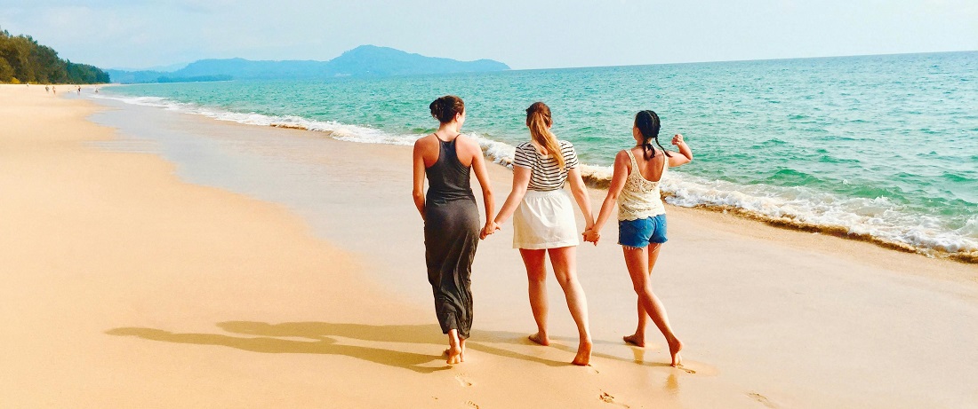 Friends walking on a beach by Julie Aagaard