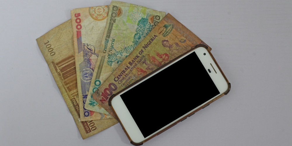 Nigerian Currency and Smartphone by Benjamin Dada