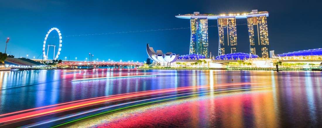 Marina Bay Sands at night, lit up with neon colours