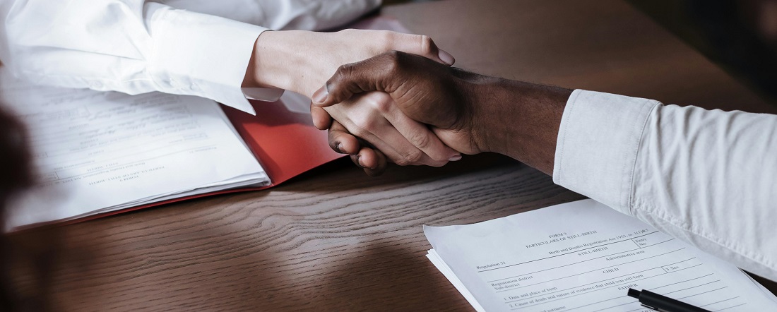 Two people shaking hands by Ron Lach