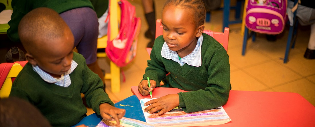 Children colouring in a classroom by Zebari Visuals