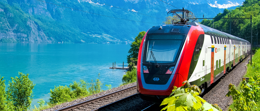 Train in Japan with water, hills and trees in background