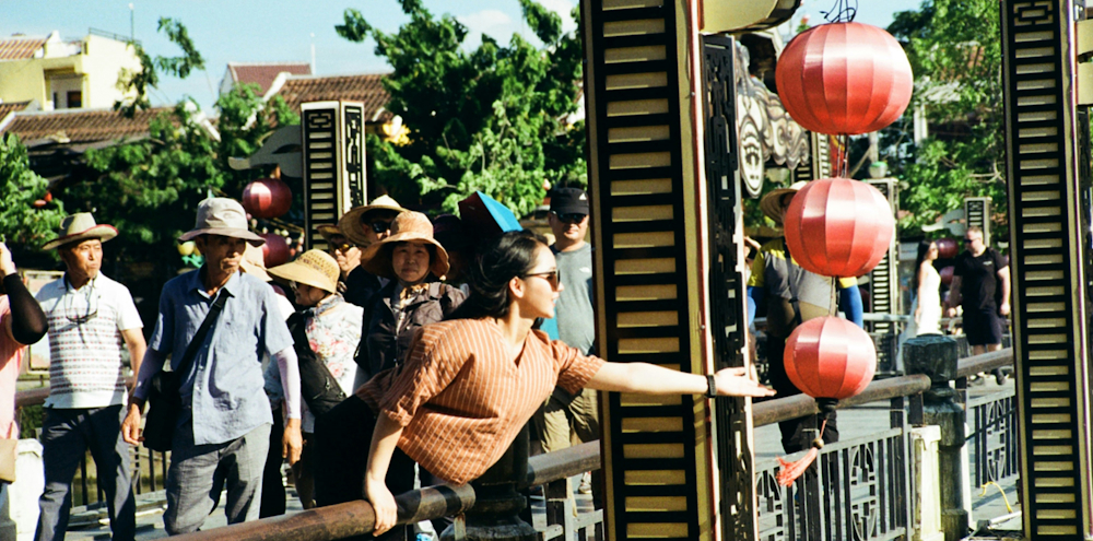 Tourist Leaning Over Railing by Phạm Chung on Unsplash