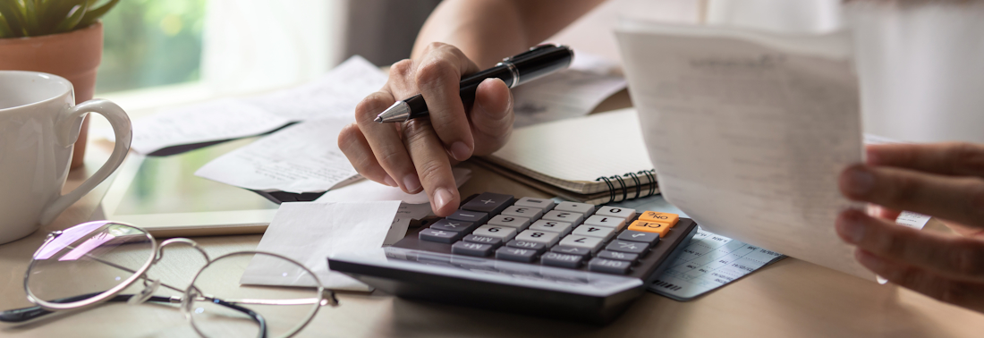 Person doing taxes using a calculator 