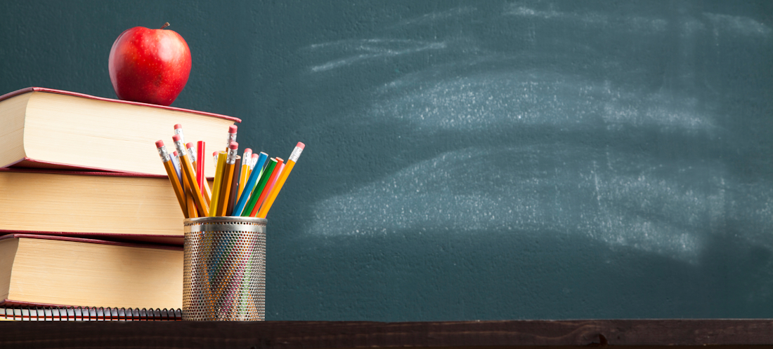 book pile with stationery and chalkboard