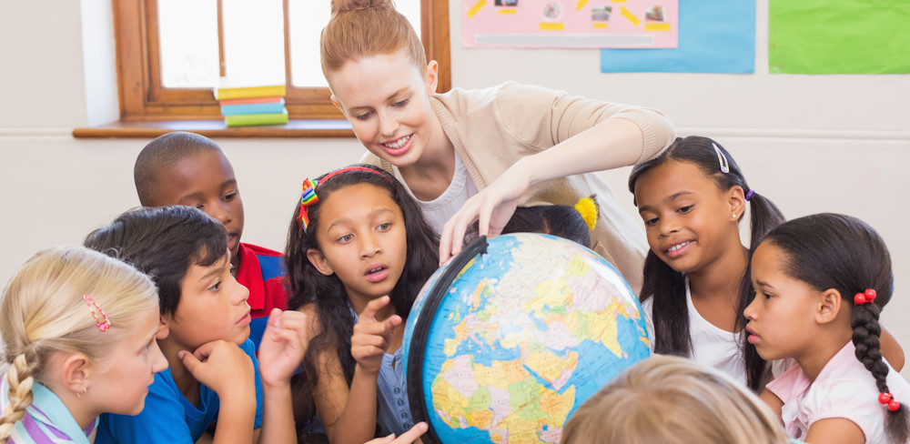 Teachers and children pointing at a globe