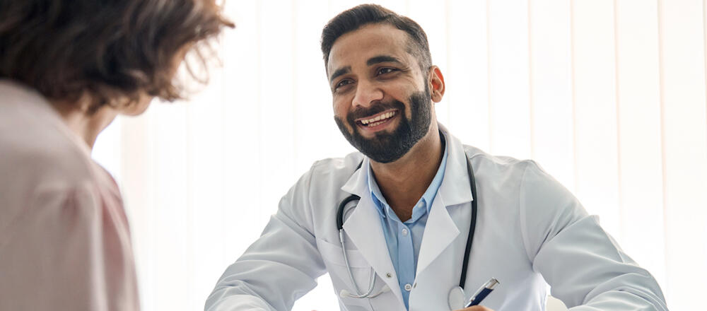 smiling doctor holding a pen in a medical setting