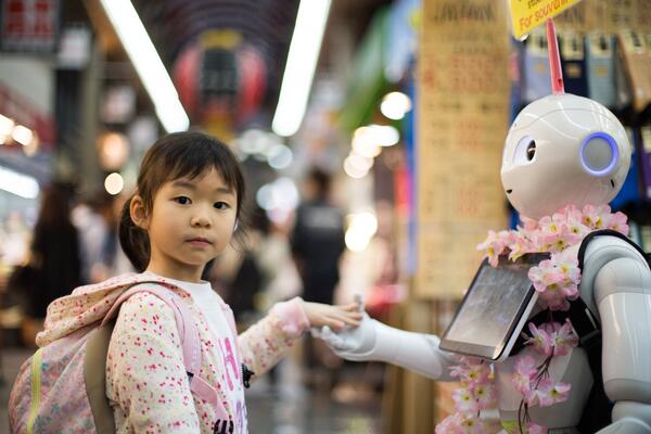Photo of a girl making friends with a robot