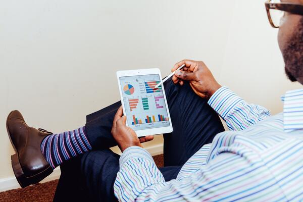 man looking at comparison graphs on a tablet